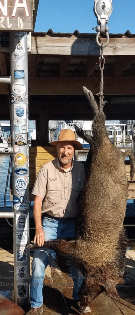 Chef Philippe Parola beside a harvested wild boar in Venice, Louisiana